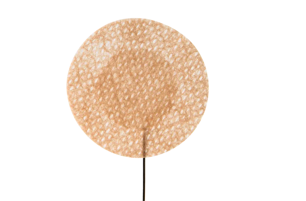Close-up of a single round cover showing its woven fabric and gauze center