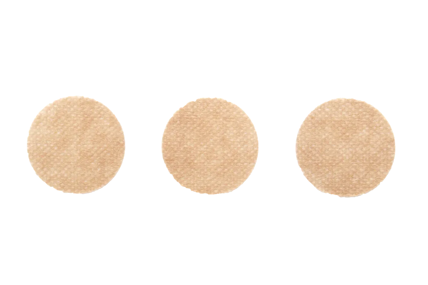 Three round nipple covers in a row on a light gray background